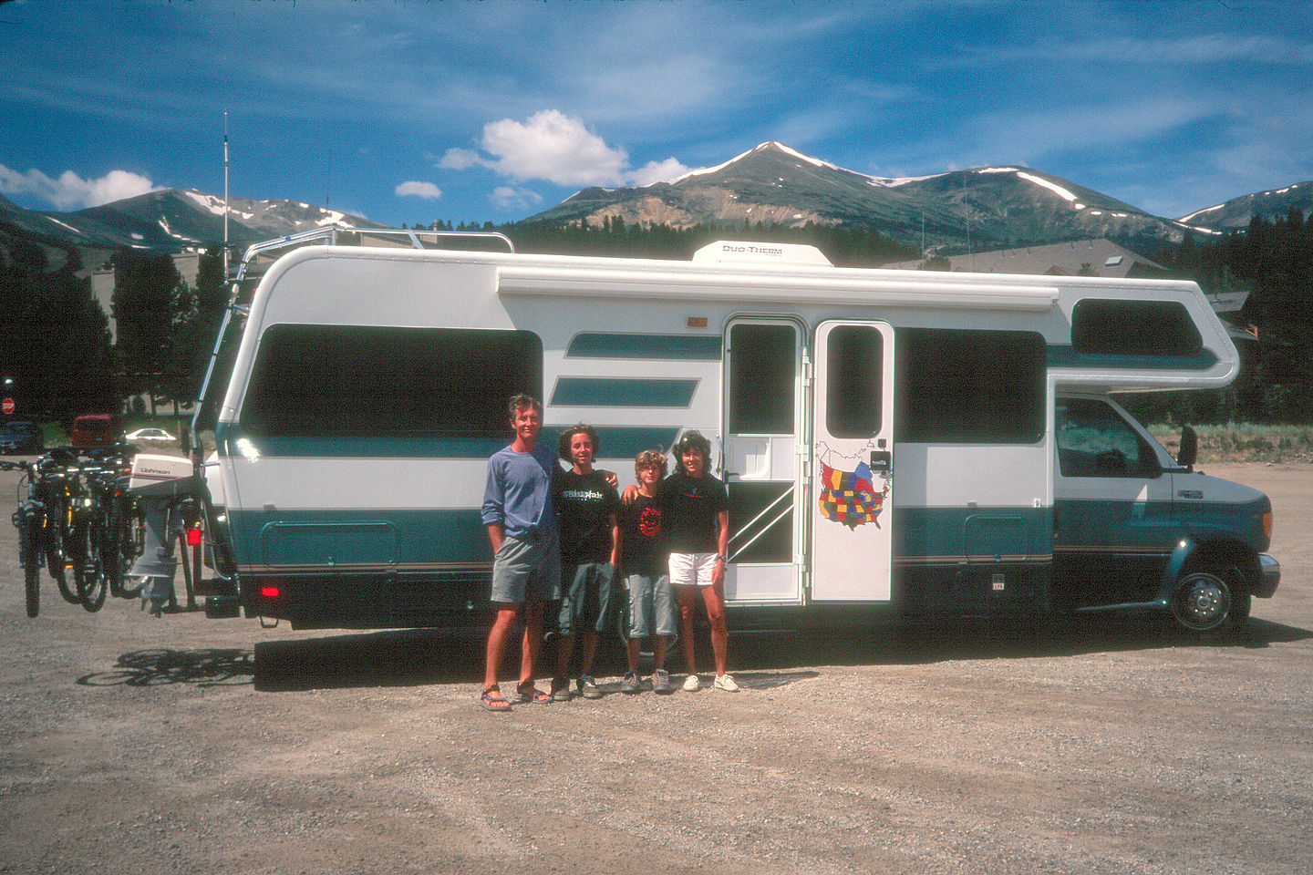 Family RV shot with snowcapped mountains