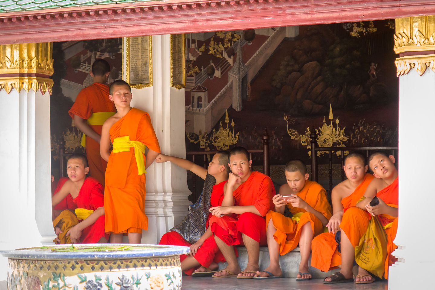Young Buddhist monks playing with their material possessions