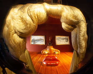 Mae West room with sofa lips, a fireplace nose, and two paintings for her eyes.